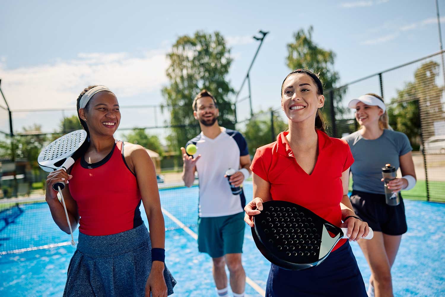 Four friends enjoying time together on a padel court